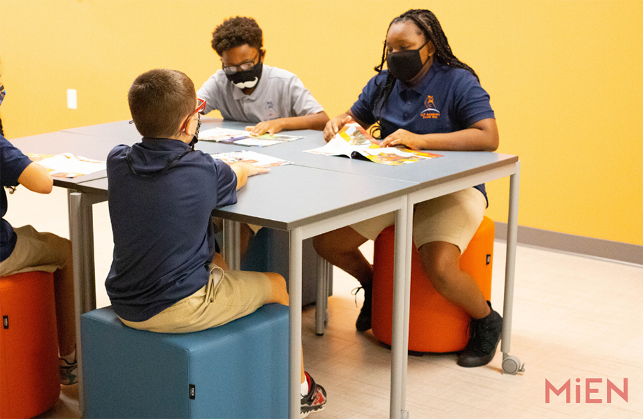 Four students on stools at Formica Laminate classroom table designed by MiEN