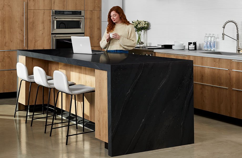 5015-11 Black Painted Marble waterfall kitchen island with 9319-BH Stainless and 9312-NG Planked Urban Oak with woman