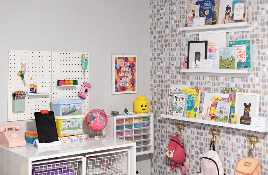 Craft room with laminate desk, peg board, shelves and books.