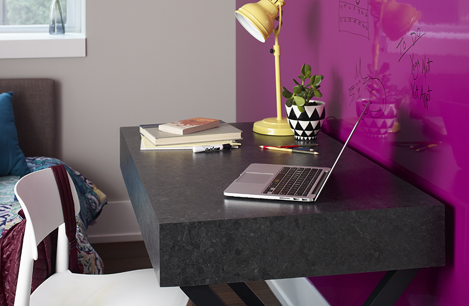 Laptop on desk with 527-34 Black Shalestone top against Formica® Writable Surfaces wall in 6907-90 Amarena