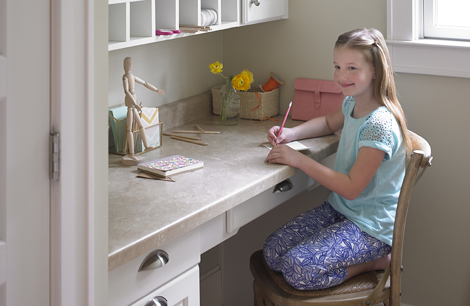 Girl sitting at desk with Formica® Laminate in 3526 Travertine