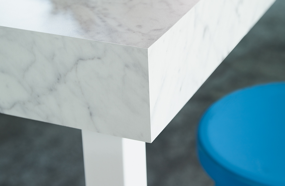 Close-up of white marbled Formica laminate tabletop corner and stool