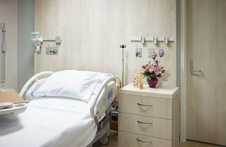Hospital bed with 7412-58 Planked Raw Oak woodgrain laminate wall, door and night stand
