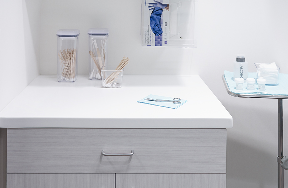 Clean and modern 109 Brite White countertops in patient room with 9285C White Twill woodgrain cabinetry on drawer