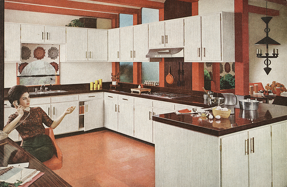Woman in vintage kitchen with white Formica laminate cabinets, woodgrain countertops and orange floor