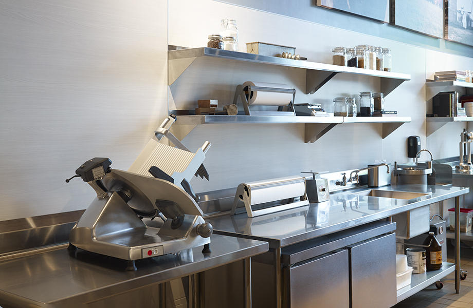 Commercial kitchen with meat slicer, stainless steel counters and 8841 White Ash HardStop decorative protection panels