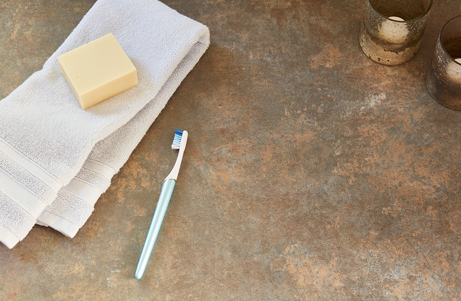 Close-up of Formica laminate bathroom counter with towel, soap and toothbrush