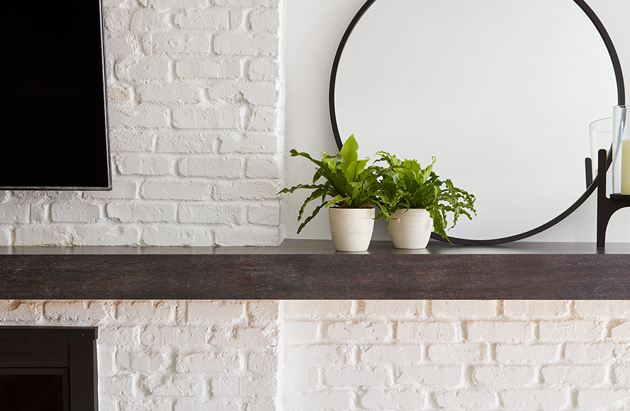 Formica laminate fireplace mantle with round mirror and plants