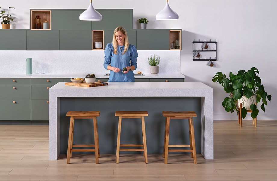 Waterfall Formica laminate island in modern kitchen with woman prepping dinner