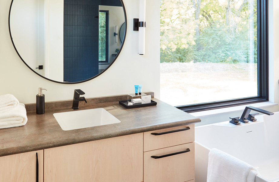 Light and bright bathroom with Burnished Coin laminate vanity countertop, mirror and tub