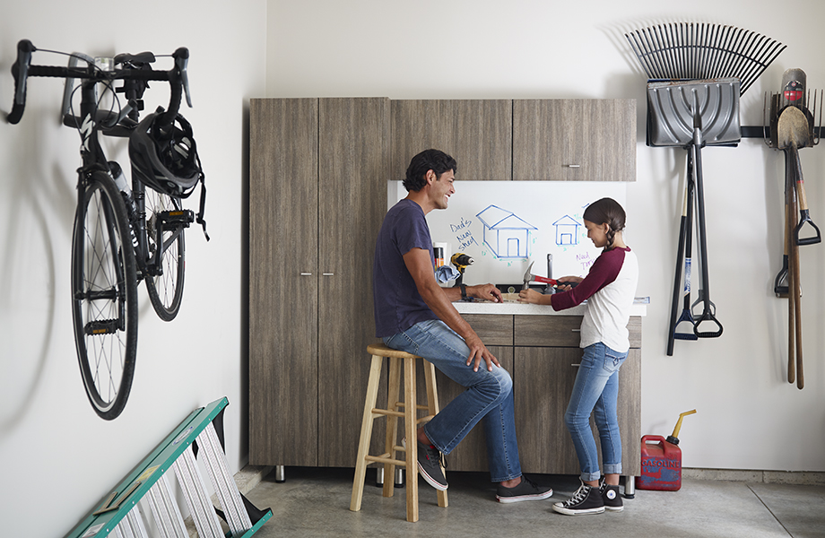 Father and daughter in garage with 8915-NG Walnut Fiberwood cabinets and 9313-90 ImagiGrid markerboard