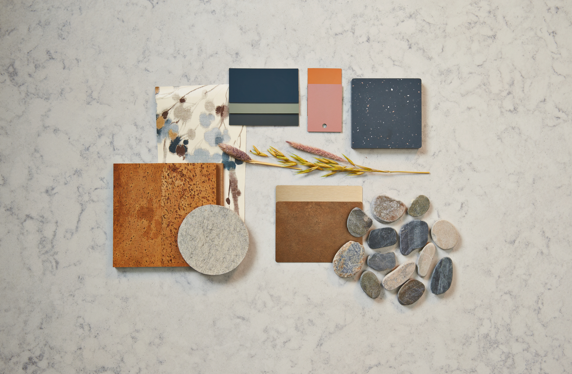 Paleta de diseño con muestras de telas azules, marrones, naranjas y crema, azulejos y maderas de Formica Group y Materiales Innovadores FENIX 
