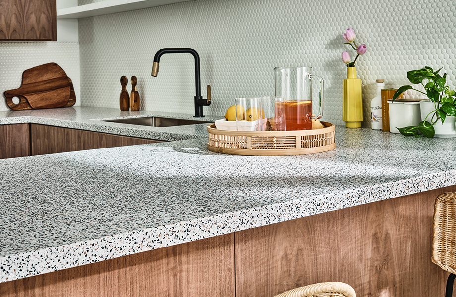 Modern kitchen with speckled acrylic solid surface countertops in 412 Dalmata Terrazzo Matrix with drinks and plant