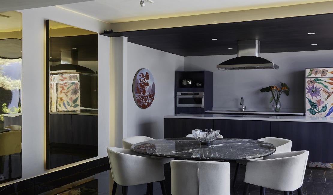 Dark Rolled Steel aplicado en la cocina, cubierta de Gamma Grey y Polished Gold Aluminum en los muros