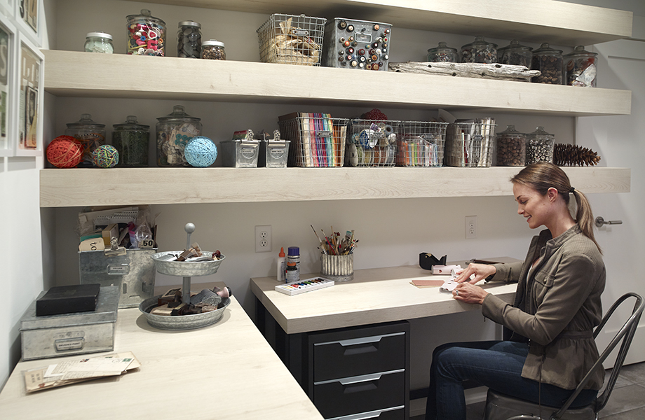 Femme assise au bureau dans une salle d'artisanat avec un plan de travail fabriqué avec le stratifié 7412-PG Planche de Chêne Brut