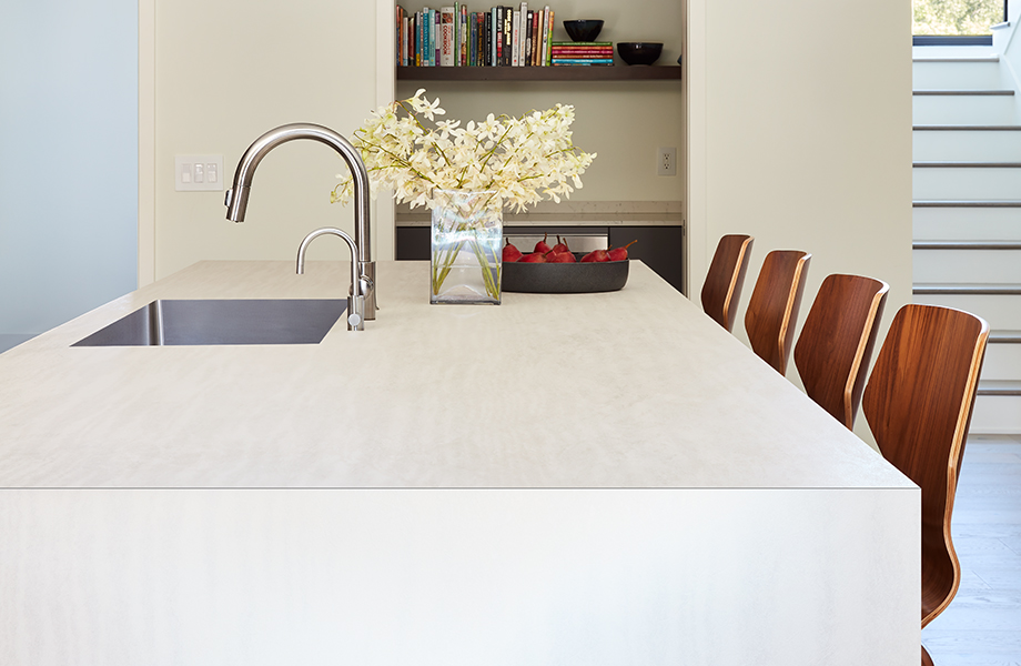 Îlot de cuisine en stratifié de marque Formica® avec bordure décorative Cascade, évier encastré et chaises.