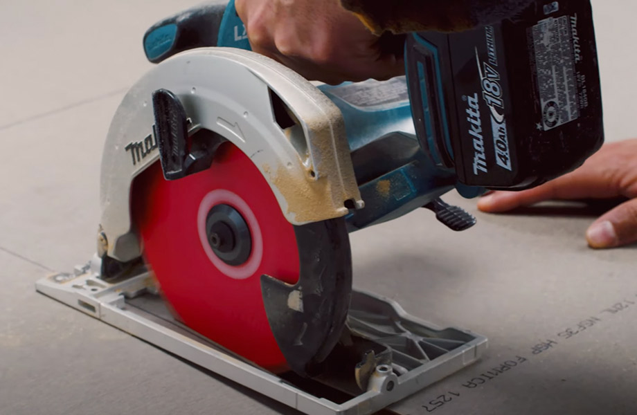 Une personne utilise une scie circulaire pour découper une feuille de stratifié de marque Formica®.